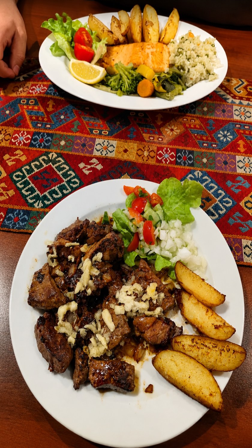 Gegrillte Fleischstücke mit Knoblauch, Kartoffelecken und frischem Salat